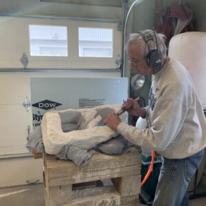 Sculptor wearing headphones working on a piece of white marble